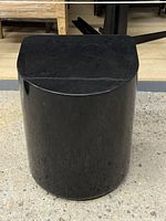 Full view of black concrete side table showing shape and finish