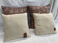 Front view showing all four pillows: two beige, two rust floral