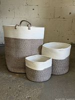 Three matching two-tone woven rope baskets displayed together