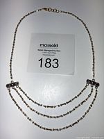Full view of tri-strand necklace showing overall design and clasp
