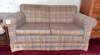 Front view of plaid loveseat showing overall design and condition
