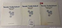 Front covers of Suzuki Violin School Volumes 1-3