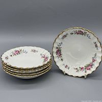 Stack of six matching floral gilt-rimmed plates