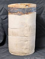 Full view of cylindrical stoneware vase showing beige body and glazed collar