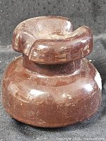 Front and side view of brown porcelain electrical insulator