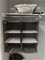 Gray six-cubby hanging shelf suspended from closet rod with basket on top