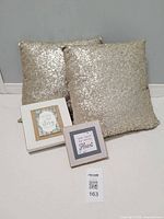 Two sequin pillows and two quote plaques displayed together