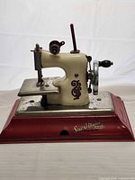Left side view of miniature sewing machine on base