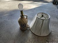 Jug lamp with bulb beside detached shade