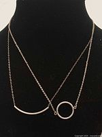 Both sterling silver necklaces displayed to show pendants and chains