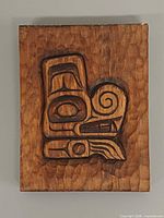 Front view of carved plaque showing full motif and wood texture