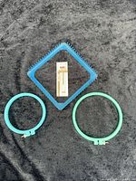 All items laid out: square loom, two hoops, needle pack