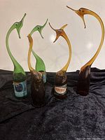 Group shot showing all five glass animal sculptures on bottle bases