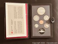 Case open showing all seven proof coins and certificate panel