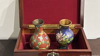 Open box showing both cloisonné vases upright