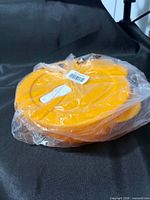 Factory-sealed yellow Tupperware dish wrapped in plastic