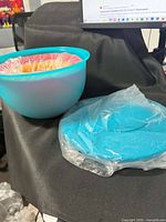 Large aqua bowl with nested smaller bowls; lids beside
