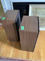 Front and top view of both speakers showing wood veneer and grille on one unit