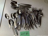 All pieces spread on countertop showing mix of knives, forks, spoons