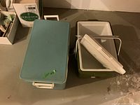 Blue and green Coleman coolers side by side, lids visible