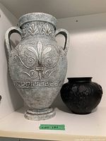 Both vases side by side on shelf