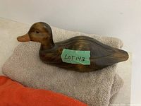 Left side of carved wooden duck on towel