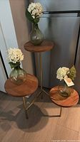 Full view of 3-tier stand with three glass vases and faux flowers