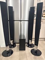 Front view showing four LG tower speakers with bases and Samsung subwoofer