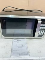 Front view of Hamilton Beach microwave oven with power cord on top