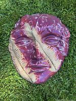 Front view of glazed ceramic face sculpture showing color and texture