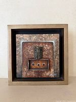 Front view of framed mixed-media artwork
