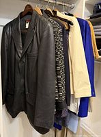 Full view of garments on rod showing leather blazer and others
