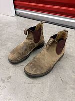Pair of brown/tan Blundstone Chelsea boots, top and side view showing scuffs and dirt