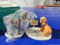 Both Lady and Tramp figurines on bases with Wet Cement sign