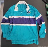 Full view of teal collared rugby shirt with stripes and logo