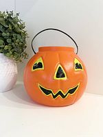 Front view of pumpkin pail showing face and handle
