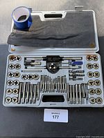 overall view of tap and die set opened in its case showing taps, dies, wrenches, screwdrivers, tape roll and foam insert