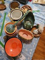 Group shot of assorted bowls, planters, ladle, incense holder and decorative orb on table