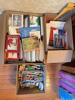 Three cartons filled with greeting cards, envelopes, pads and stationery