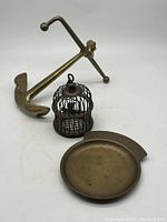 Overview of all three brass items: anchor, birdcage, coin tray