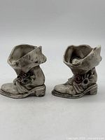 Front view of both porcelain boots showing floral details and glaze finish