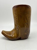 Right side view of brown glazed ceramic cowboy boot planter with scroll relief