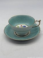 Cup on saucer angled side view showing exterior color and gold trim