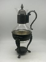 Full view of glass carafe with silver-plated lid, handle and stand