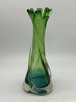Front view of green art glass swung vase showing twisted body and ruffled rim