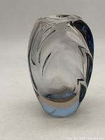 Front view of thick clear glass vase with blue-grey swirl pattern