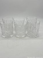 Front view of six clear cut-crystal style whiskey glasses
