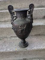 Full front view of bronze urn showing overall form and relief details