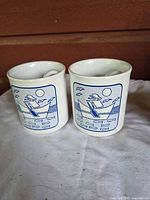 Front view showing nautical boat graphic on both mugs