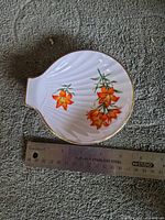 Top view showing floral decal, moulded ribs, gold trim and ruler for size